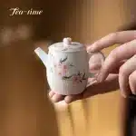 「桃影壶 · Spring Whisper」 — 130ml Pure Hand-Painted Peach Blossom Teapot (Modern Chinese Style · Porcelain Clay Body · Built-in Chhai Filter · Handmade for Puer & Gongfu Brewing)